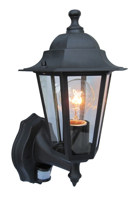 A black framed lantern with clear glass panels and a visible warm light bulb on a white background.