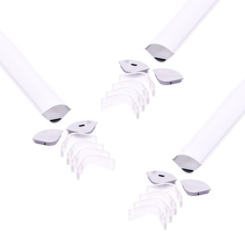 Three sets of corner mounting aluminium LED profiles with white diffusers laid out on a white surface with their included mounting brackets and end caps.