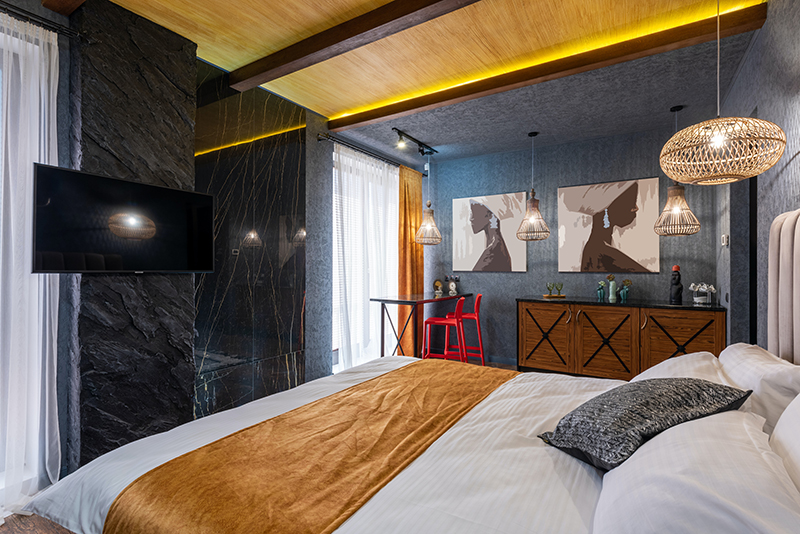 moody bedroom with warm white strip lights on the ceiling beams