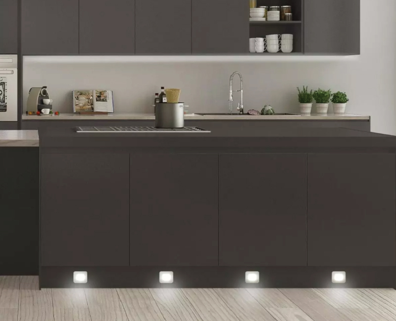 dark wood kitchen island with plinth lights in cool white light