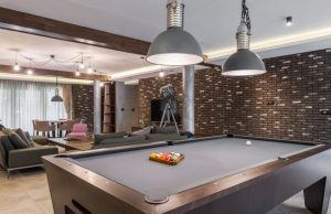 Man Cave with a pool table, and led lighting with TV on the wall