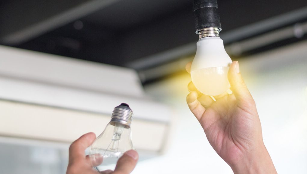 Hand with a lit light bulb