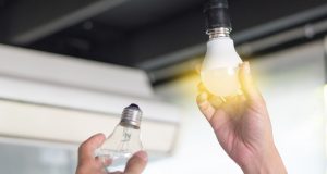 Hand with a lit light bulb