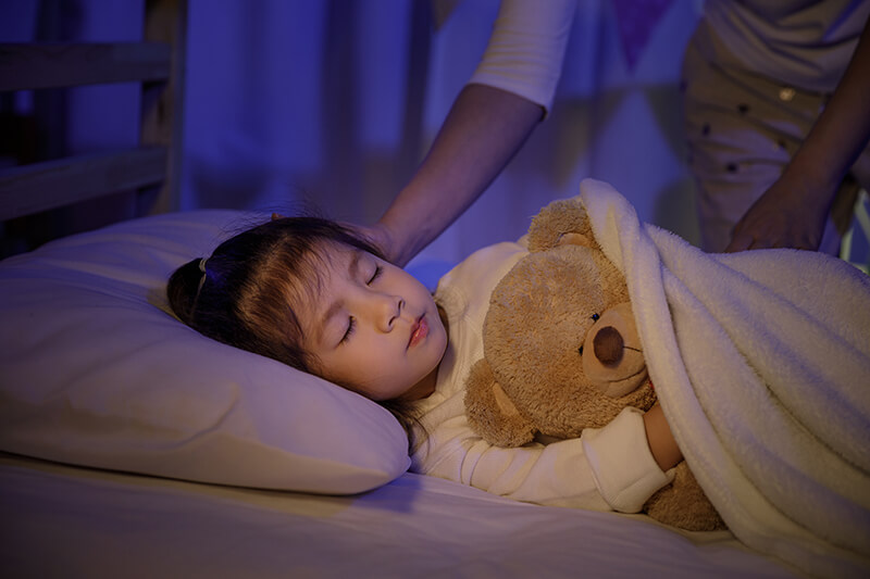 little girl sleeping while hugging a teddy bear