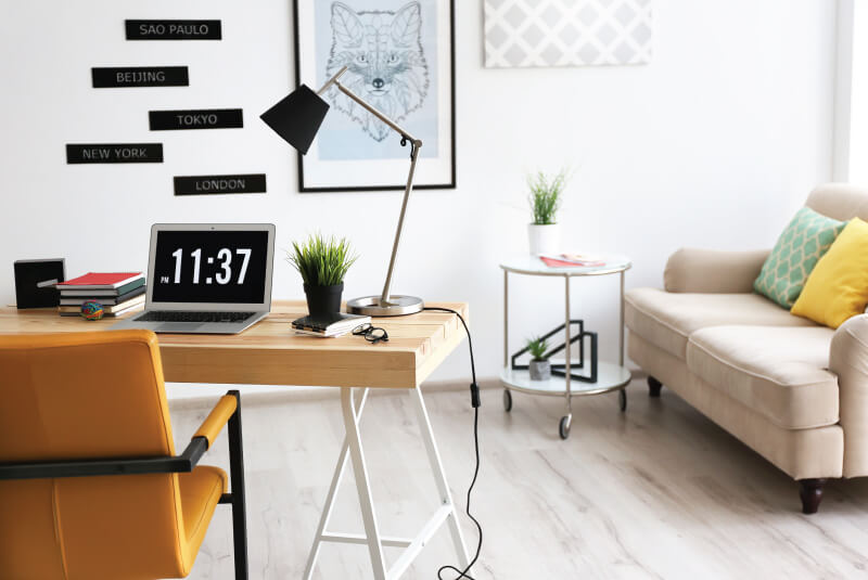 wooden table with desk lamp and laptop