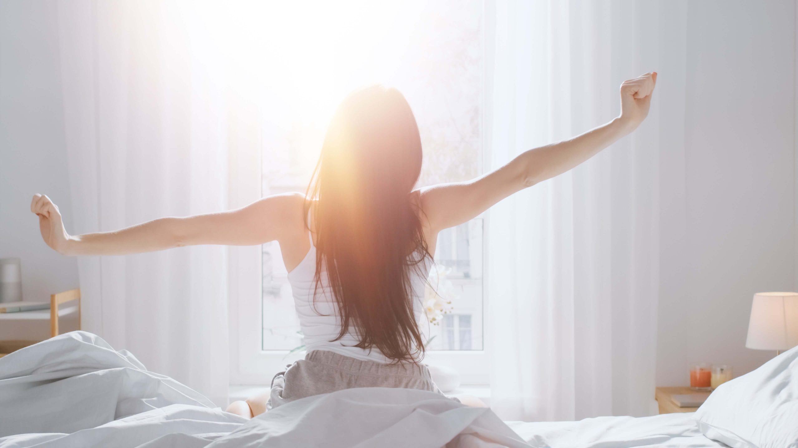 girl opening the white window curtains