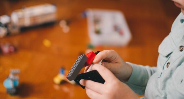 boy holding Legos