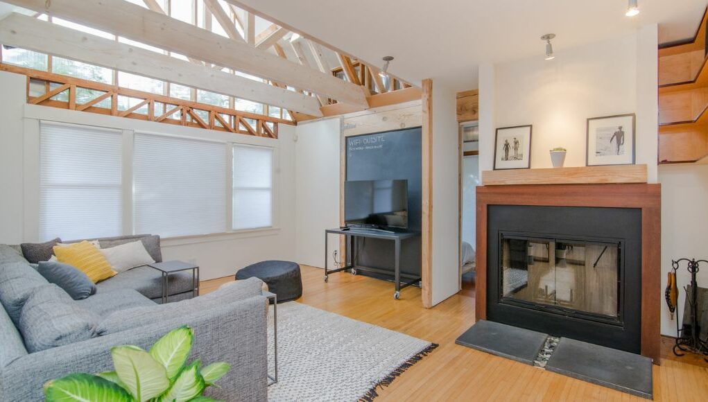 living room with light wood floors and beams