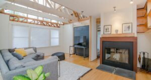 living room with light wood floors and beams