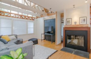 living room with light wood floors and beams