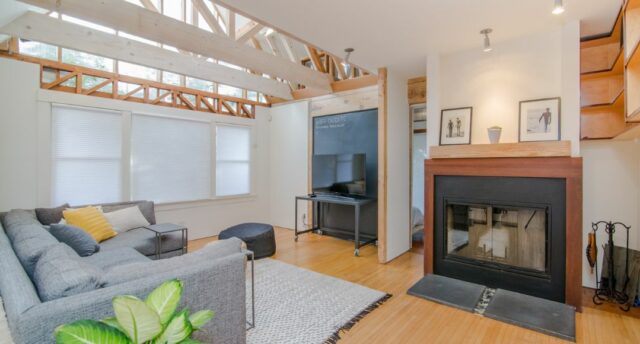 living room with light wood floors and beams