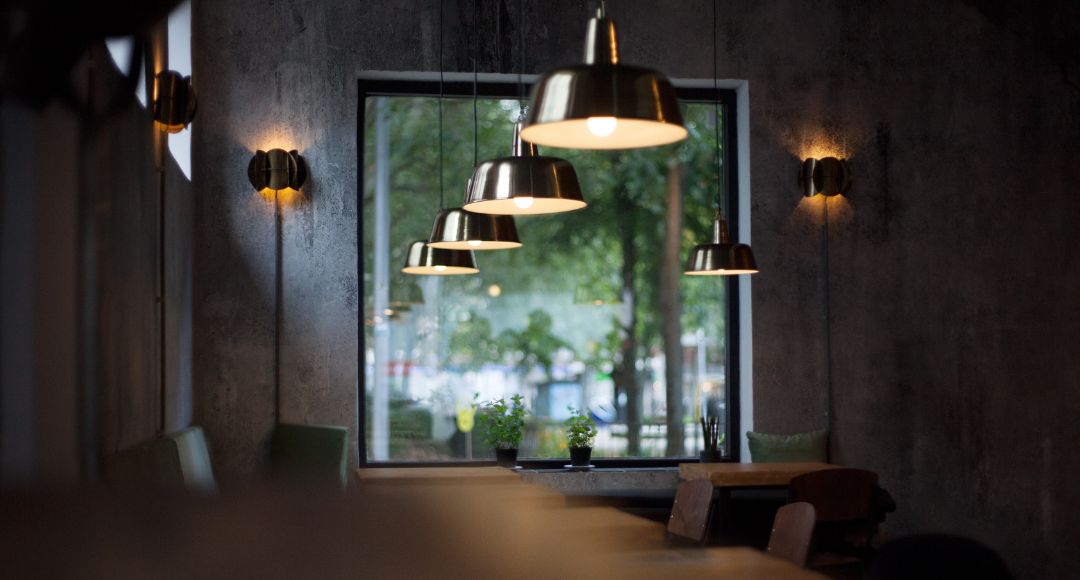 pendant lights hanging in a line over a table