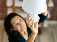 woman changing a light bulb