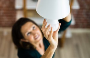 woman changing a light bulb