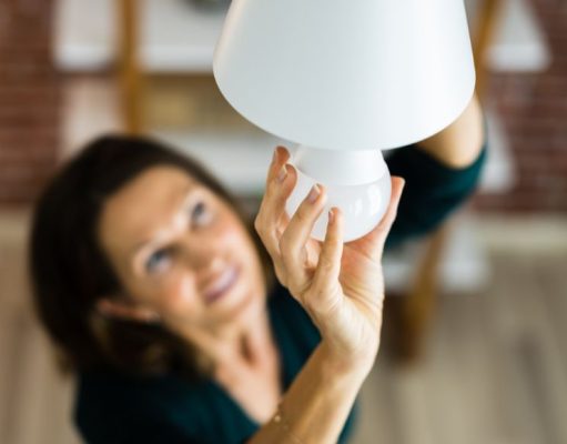 woman changing a light bulb