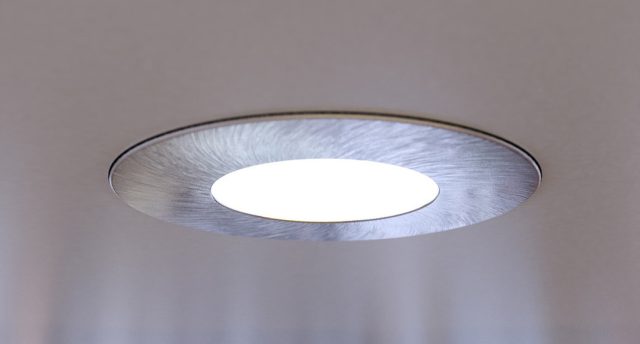 A close up of an LED downlight brightening up a living room.