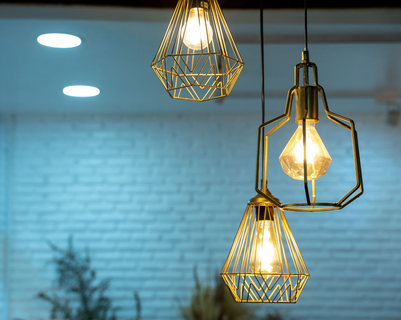 three warm colored light bulbs hanging from ceiling