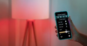 Homeowner holding their phone and adjusting their space's lighting.