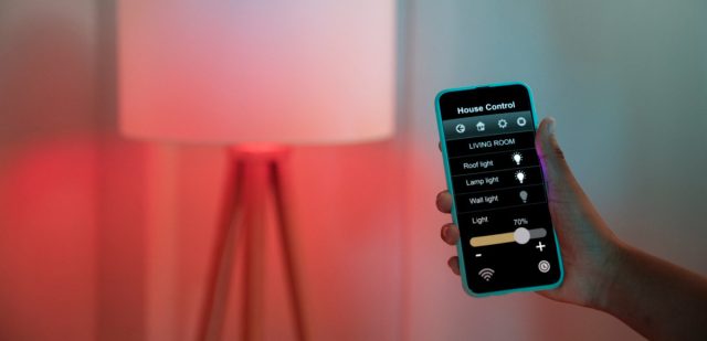 Homeowner holding their phone and adjusting their space's lighting.