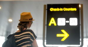 Woman looking at backlit airport sign