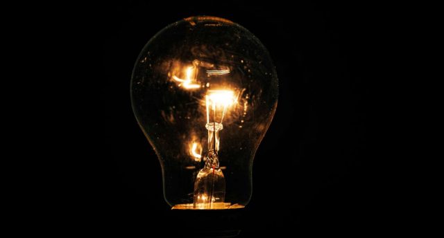 Lit incandescent light bulb with visible filaments