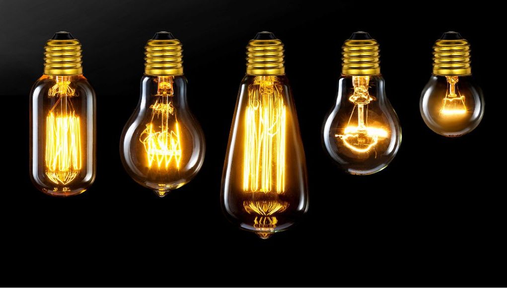 Different incandescent bulbs lined up, black background