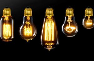 Different incandescent bulbs lined up, black background