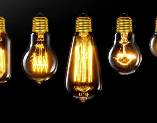 Different incandescent bulbs lined up, black background