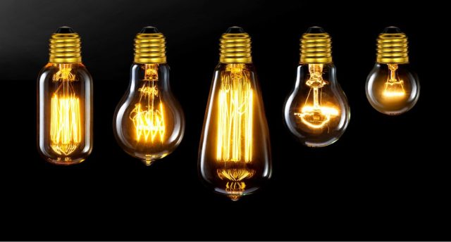 Different incandescent bulbs lined up, black background