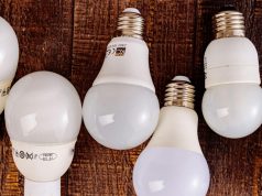 Light bulbs alternately lined up on a table with labels showing on some