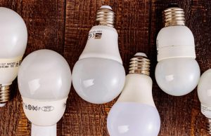 Light bulbs alternately lined up on a table with labels showing on some