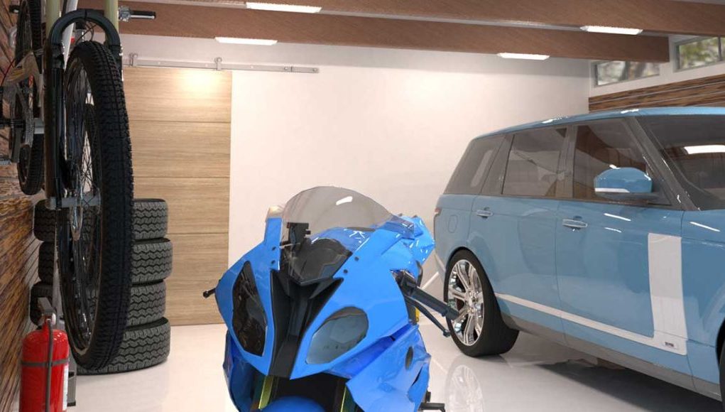 A well-lit garage with a blue car and motorcycle and multiple batten lights on the ceiling.
