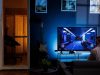 A person gaming in a dark room, his screen has a blue backlighting.