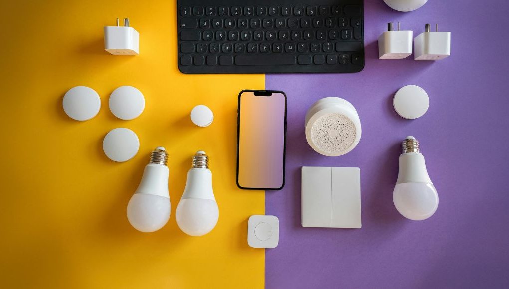 LED bulbs and other electronics laid out on a yellow and purple table.