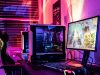 A gaming PC setup with bright red, orange, purple, and blue lights at the back of the monitor.