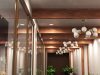 Hallway with exposed wood beams and a series of pendant lights and downlights.