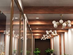 Hallway with exposed wood beams and a series of pendant lights and downlights.