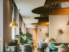 A brightly lit restaurant with brass fixtures and warm lighting.