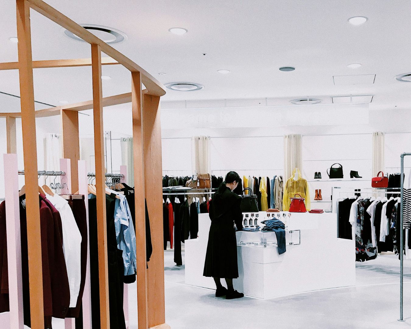 A woman in a clothes store browsing through a display.