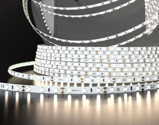 LED Strip Brightness & Density Demystified: How to Get Perfect Lighting A roll of Simple Lighting LED strip light that's glowing with a bit of a warm white light, on a dark surface and background.