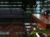 An outdoor deck that's wet from rain with multiple strip lighting on the perimeter wall.