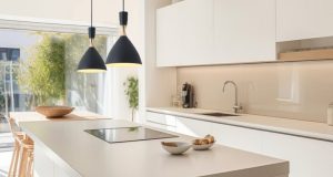 A modern kitchen with an island and two hanging pendants over it.
