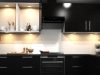 Modern Kitchen Lighting Trends for 2025 A kitchen with dark cabinet doors and warm lighting.