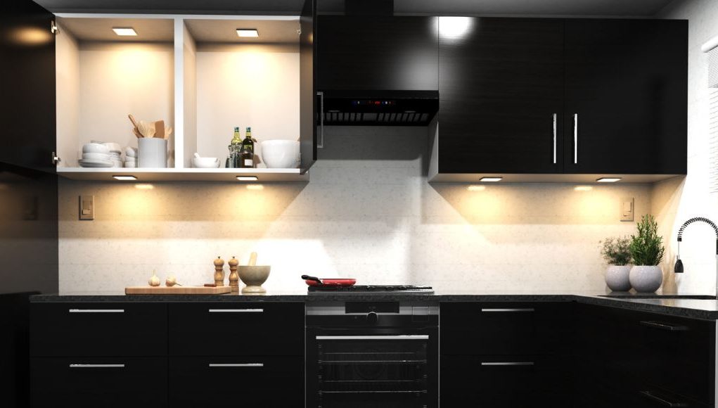 Kitchen Trends 1 A kitchen with dark cabinet doors and warm lighting.