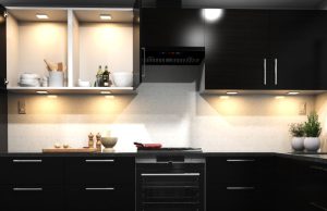 A kitchen with dark cabinet doors and warm lighting.