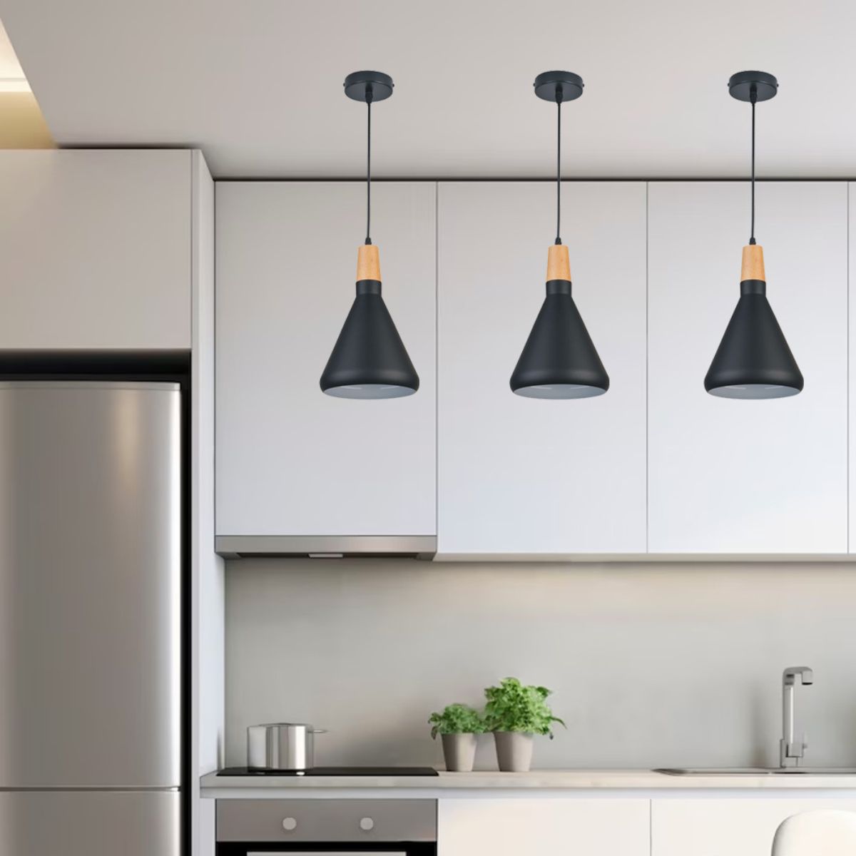 Three black matte pendant lights hanging from a modern kitchen ceiling.