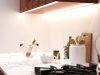 Kitchen Lighting Mistakes to Avoid A bright kitchen countertop with various kitchen stuff with under-cabinet strip lighting for illumination.