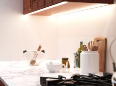 Kitchen Lighting Mistakes to Avoid A bright kitchen countertop with various kitchen stuff with under-cabinet strip lighting for illumination.