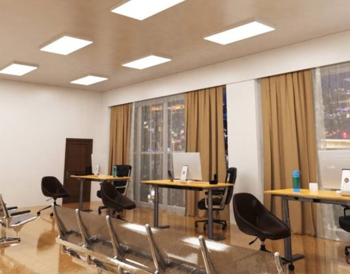 An open office space with three desks near two big glass windows and multiple LED panel lights on the ceiling.