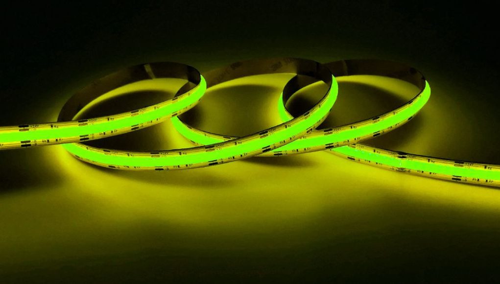 A lit up yellow-green strip light in a dark room.